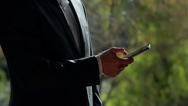 Молодой человек в костюме с помощью смартфона — стоковое видео