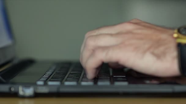 Primer plano de manos masculinas escribiendo en un teclado portátil — Vídeos de Stock