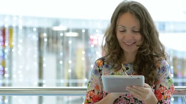 Young Beautiful Girl Using Tablet In A Public Place — Stock Video