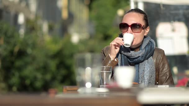 Jeune femme buvant du café dans un café extérieur — Video