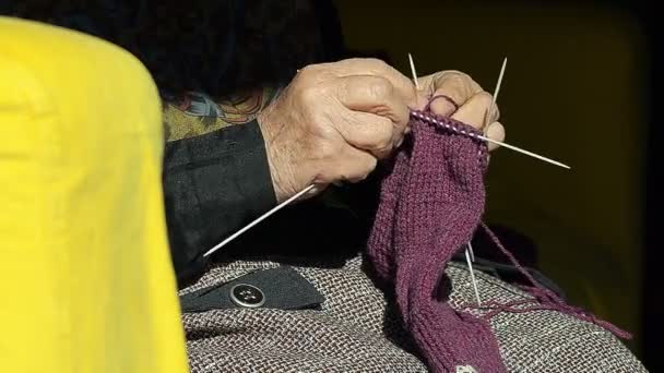 Nahaufnahme einer Großmutter, die Wollsocken auf der Couch strickt — Stockvideo