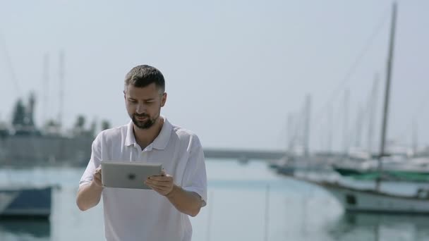 Νεαρός άνδρας χρήση Ipad στην Μαρίνα — Αρχείο Βίντεο