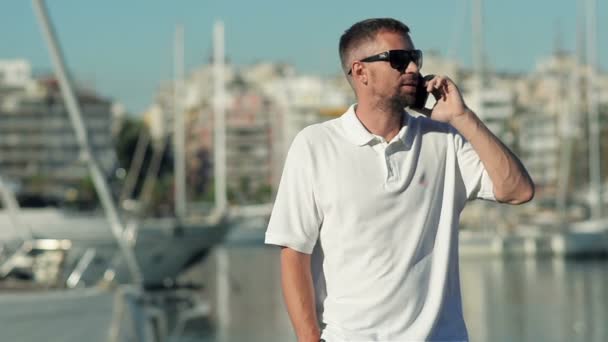 Mladý muž mluvil po telefonu v Yacht klubu — Stock video