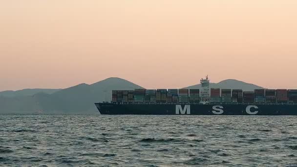 Nákladní loď plná kontejnerů plovoucí v moři při západu slunce — Stock video