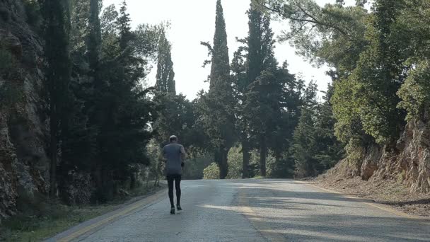 Спортсмен підбігли на гірській дорозі — стокове відео