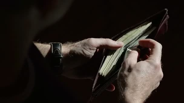 Mirando en una cartera de hombres mientras tamiza a través de billetes de cien dólares — Vídeos de Stock