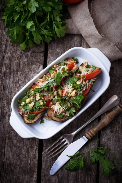 Berenjena al horno con queso, tomate, hierbas y frutos secos . — Foto de Stock