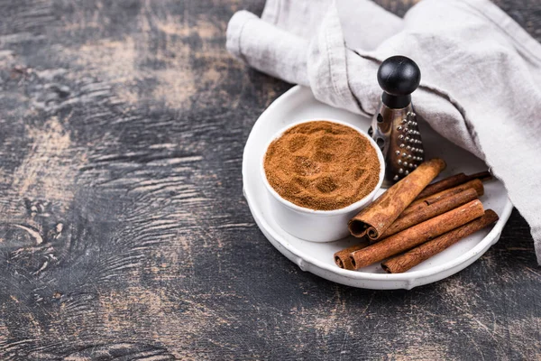 Varas de canela e pó em preto — Fotografia de Stock