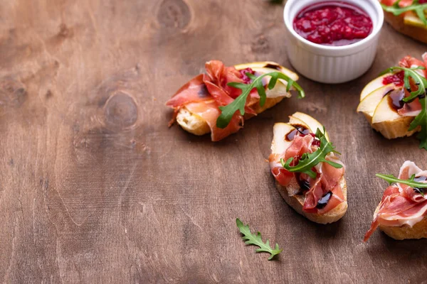 Toasts with pear and prosciutto — Stock Photo, Image
