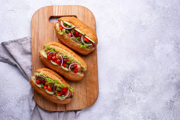Хот-доги с колбасой, соусами и овощами — стоковое фото