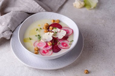 Karnabahar ve patates çorbası turpla süslenmiş.