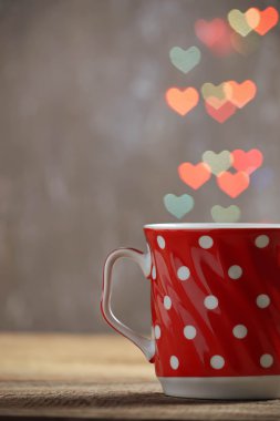 Kırmızı kalp bokeh arka planda çay fincan