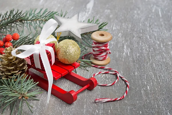 Composición navideña con trineos, rama de abeto, caja de regalo — Foto de Stock