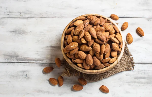 Almonds in wooden brown bowl — Stock Photo, Image