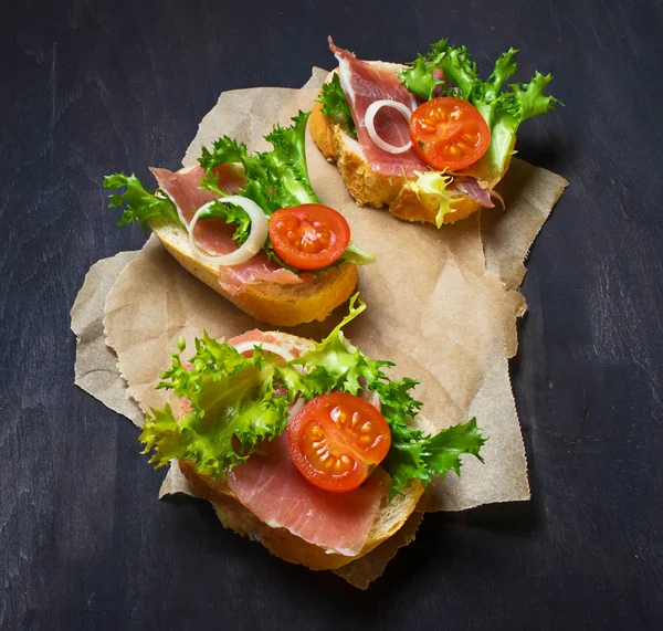 Italian antipasti crostini with ham, salad and tomato — Stock Photo, Image