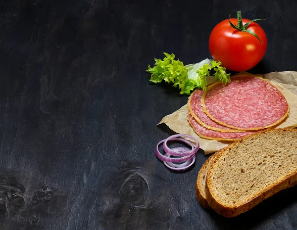 サンドイッチの食材: パン、トマト、サラミ、サラダ、オニオン — ストック写真