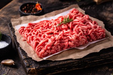 Koyu arkaplanda baharatlı çiğ et.