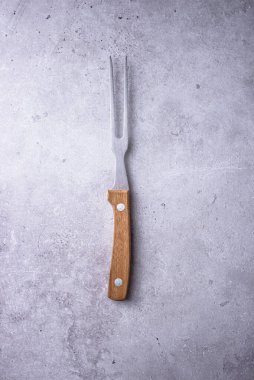 Gri arka planda ahşap saplı et çatalı