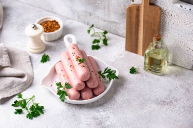 Arka planda baharatlı haşlanmış domuz sosisi.