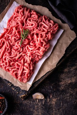 Koyu arkaplanda baharatlı çiğ et.