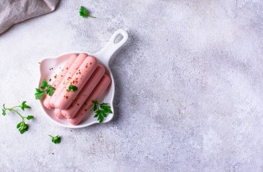 Arka planda baharatlı haşlanmış domuz sosisi.