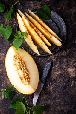 Taze taze olgun sulu dilimlenmiş kavun koyu arka planda