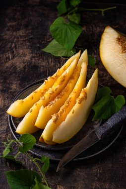 Taze taze olgun sulu dilimlenmiş kavun koyu arka planda