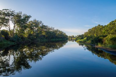 Gün batımında güzel yansımaları olan bir köprüye doğru akan sakin bir nehir.
