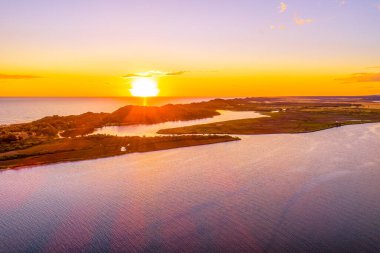 Okyanus kıyı şeridi üzerinde güzel bir günbatımı - hava manzarası. Marlo, Victoria, Avustralya