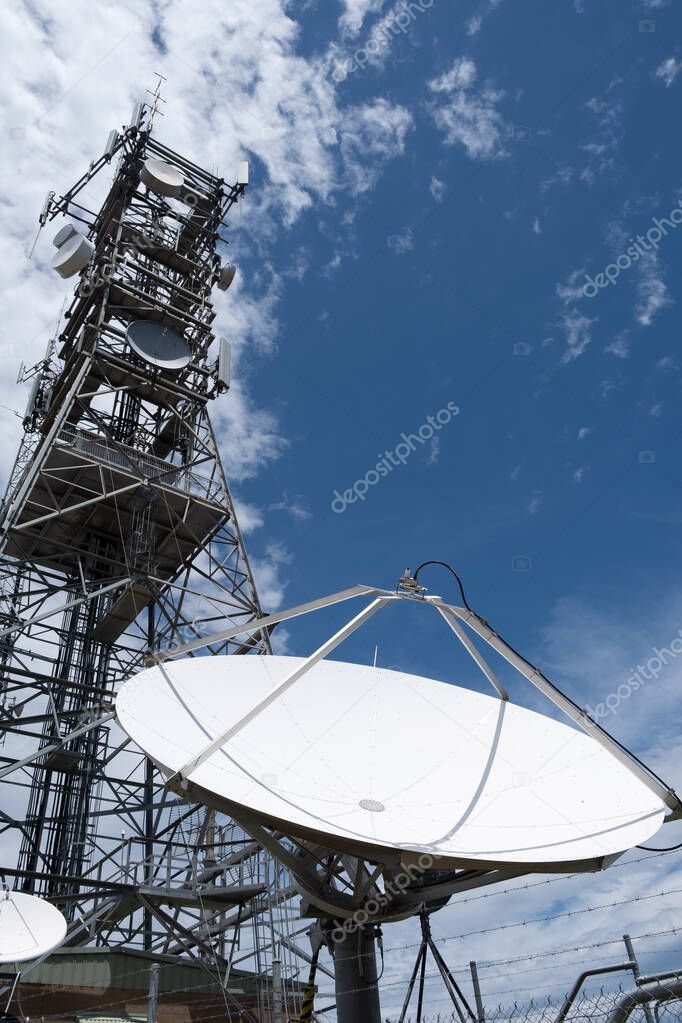 Dish antenna against blue sky - vertical image