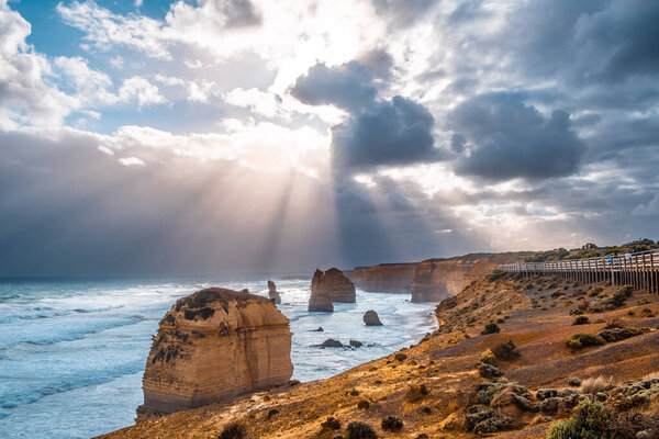 Двенадцать апостолов удивительный пейзаж - солнце за штормом в Виктории, Австралия