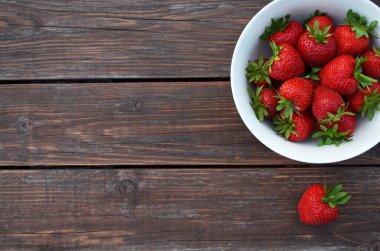 Tahta bir masada taze kırmızı çilekler.