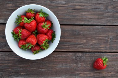 Beyaz bir kasede taze toplanmış çilek.