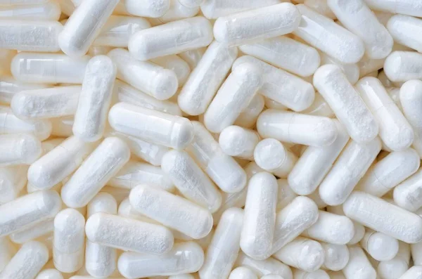 Massor av vita piller-kapslar som bakgrund — Stockfoto