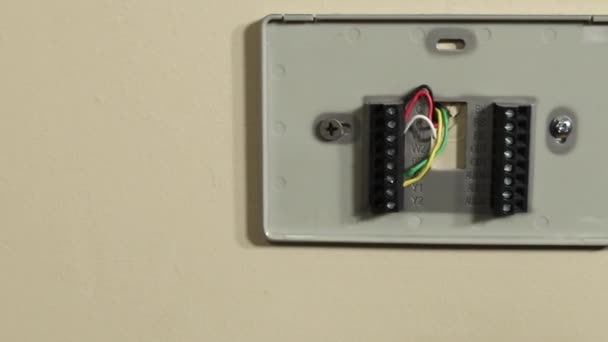 Slow slide of camera to reveal thermostat wiring and bracket on wall — Stock Footage Slow Slide Camera Reveal Thermostat Wiring Bracket Wall Royalty Free Stock Video