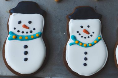 Mutlu kardan adam gibi görünmek için süslenmiş sevimli Noel kurabiyeleri.