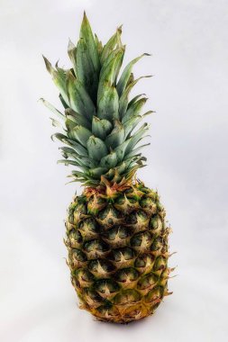 Beyaz bir arka planda canlı yeşil önlüklü Taze Ananas