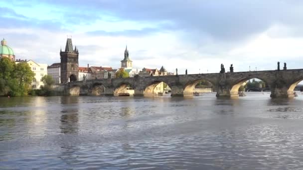 1402年からのカレル橋と流れるヴルタヴァ川の眺め チェコ共和国の日没時にプラハ中心部での橋や交通 — ストック動画