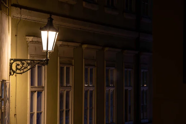 チェコ共和国の旧市街の中心部で雨が降った後の石畳と光の反射のある街灯と歩道 — ストック写真
