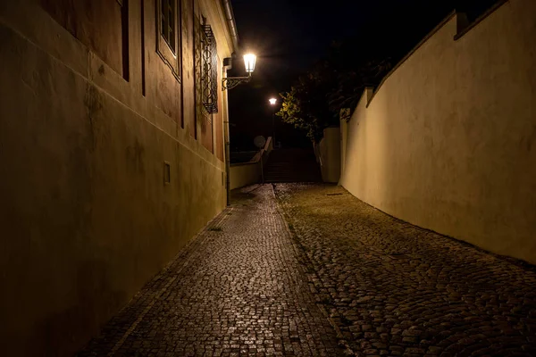 捷克共和国布拉格老城区中心地带的雨后 街上的路灯和人行道上闪烁着鹅卵石和光的倒影 — 图库照片