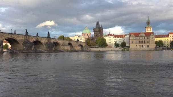 starý kamenný Karlův most ze 14. století na hladině Vltavy, ozářený sluncem při západu slunce v centru Prahy a mraky na obloze. tekoucí Vltava v centru hlavního města Prahy 