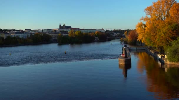 ヴルタヴァ川とプラハ城の景色日没時にプラハの中心部に聖ヴィート大聖堂とカレル橋 川の水面に反射があり空は太陽に照らされ — ストック動画
