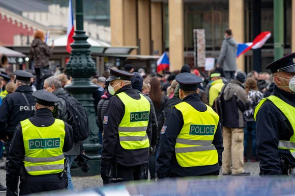 警察官は 10月28日に雨の中 チェコ共和国広場のプラハ中心部で政府の措置に反対する群衆を監督しています — ストック写真