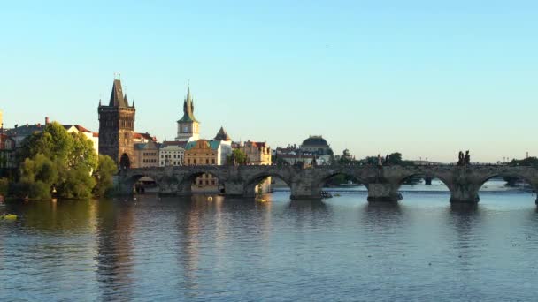 14世紀の古い石造りの橋が流れるヴルタヴァ川のプラハ市の中心部からの眺め像があり 空はチェコ共和国の日没時に青い — ストック動画