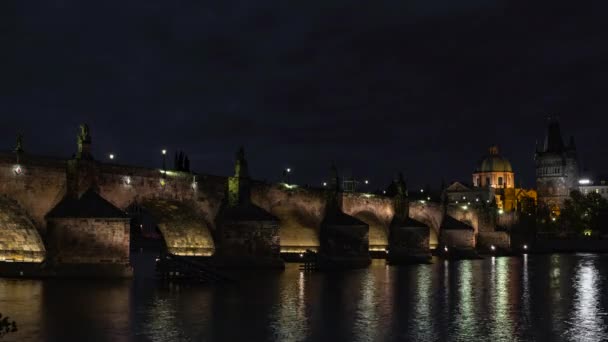 ヴルタヴァ川の流れる時間の経過と空の雲の移動とチェコ共和国の夜にプラハの中心部にあるチャールズ橋のライトアップ — ストック動画
