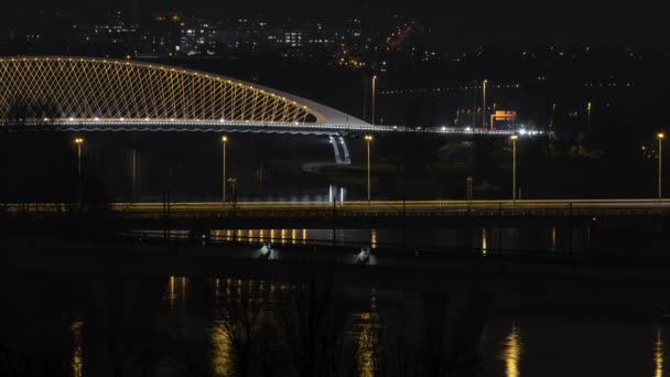チェコ共和国のプラハで夜の橋の上の街灯や車からのヴルタヴァ川の流れと光の時間経過 — ストック動画