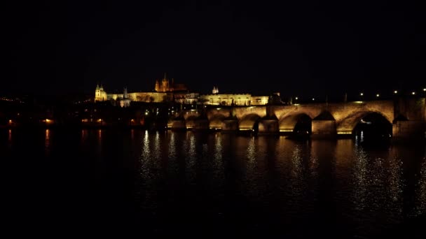 Statische Ansicht der beleuchteten Karlsbrücke aus Stein und des fließenden Flusses Moldau und Beleuchtung der Straßenbeleuchtung im Zentrum von Prag in der Tschechischen Republik bei Nacht
