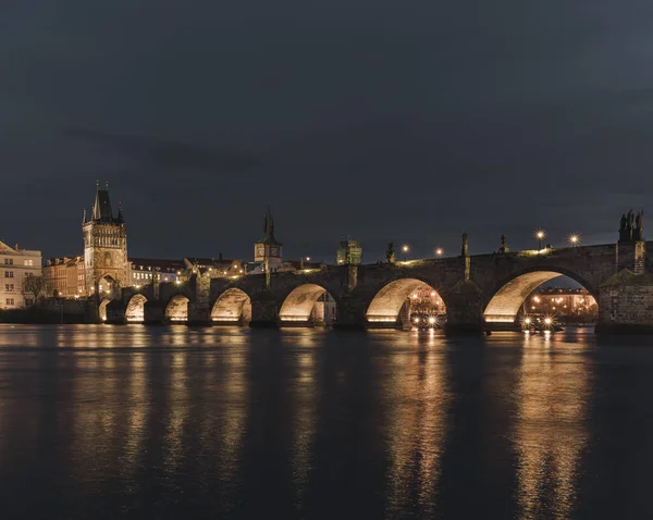 Charles Bridge and light from street lights in Prague and the level of the Vltava River after sunset in the Czech Republic