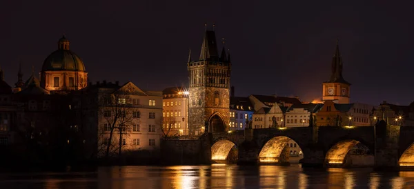 夜のカレル橋とチェコの夜のプラハ中心部のヴルタヴァ川沿いの街灯からの光 — ストック写真