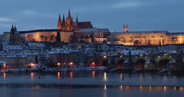 časový odstup Pražského hradu a Karlova mostu a tekoucí vltavy v noci v centru Prahy a světla z pouličního osvětlení